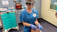 A Duke HeaNurse Alyssa Davy tests a face shield while practicing on a medical mannequin in Duke University’s simulation lab.